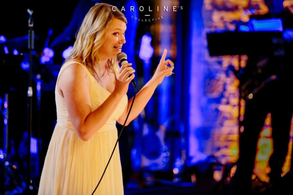 bride-speaking-at-wedding-with-blue-uplights-in-background