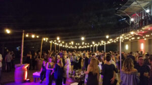 string-lights-for-outdoor-venue-crowded-and-purple-uplights