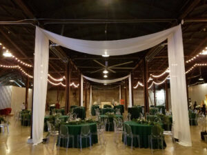 white-drape-with-emerald-tables-in-dark-venue