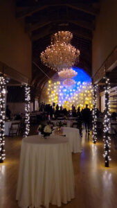 fairy-light-curtain-and-blue-dance-floor-lights-across-venue-with-dining-area-set-up
