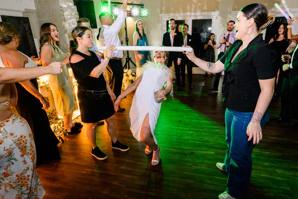 green-dance-floor-light-gleaming-as-bride-plays-limbo