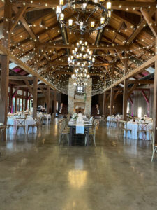 metal-chandelier-and-string-lights-across-barn-venue