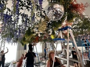 setting-up-floral-pieces-with-disco-ball-rental