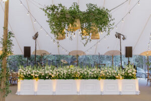 boho-yellow-uplights-in-front-of-florals-at-wedding
